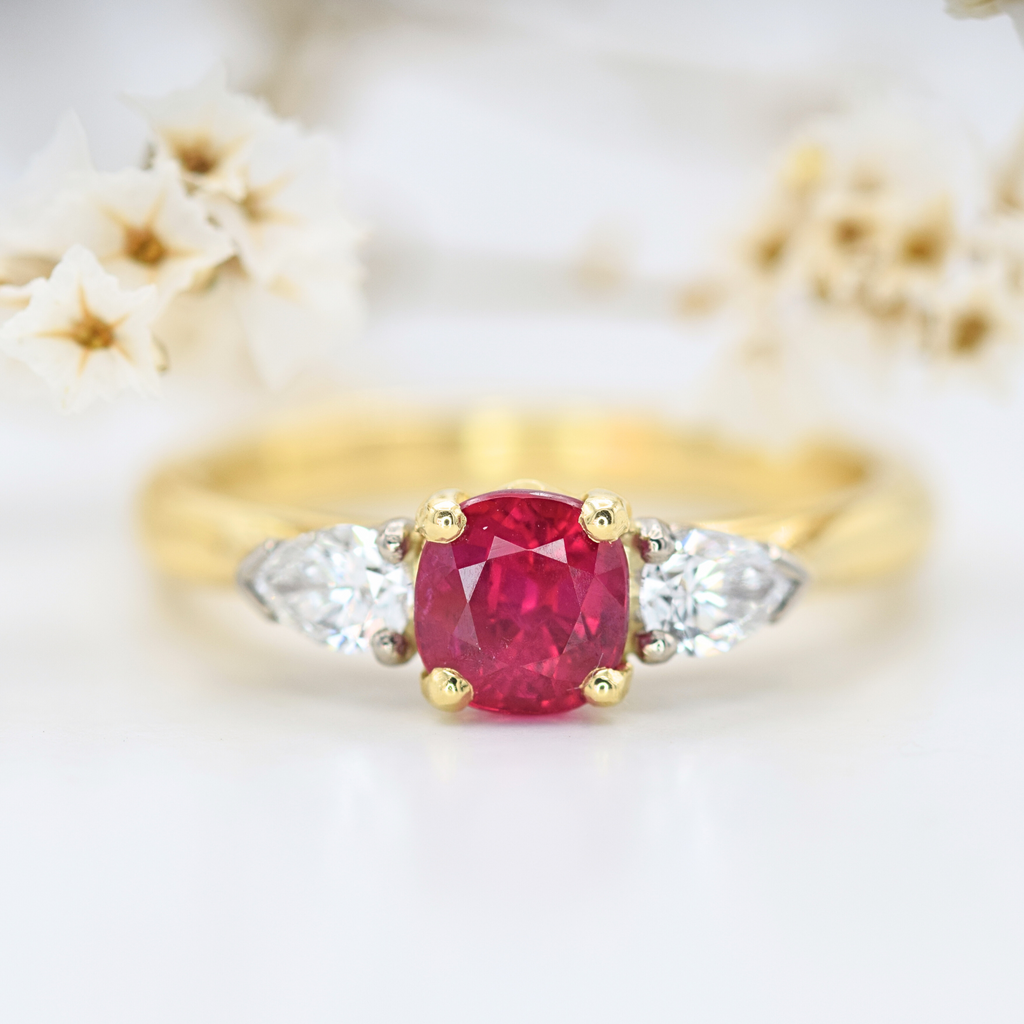 cushion cut ruby three stone ring with pear cut diamonds and yellow gold band