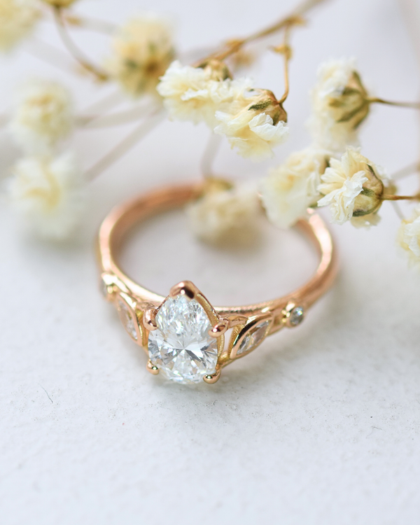lab-grown pear diamond with marquise and round natural diamond side stones in 18k rose gold