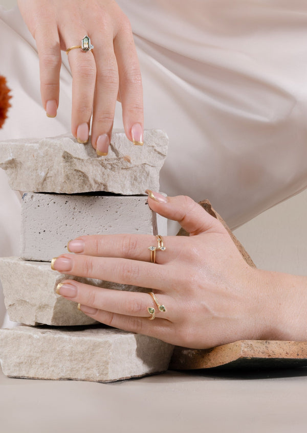 model hand shot with three yellow gold and coloured gemstone rings