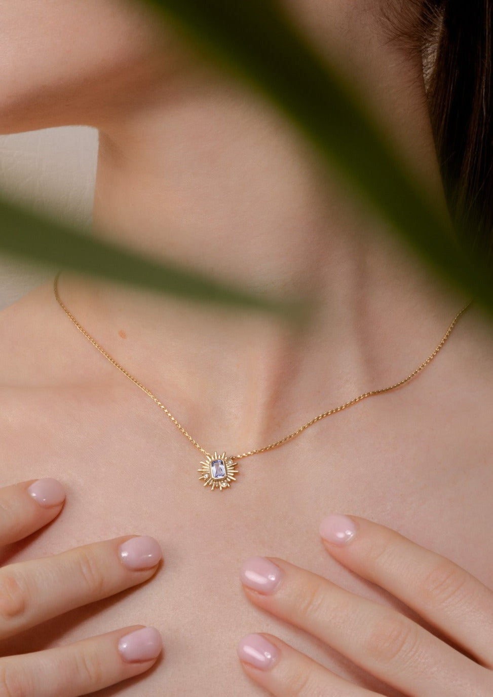 model shot wearing purple sapphire starburst pendant in yellow gold