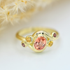 oval peach padparadscha with yellow and purple sapphire side stones in 14k yellow gold chunky ring