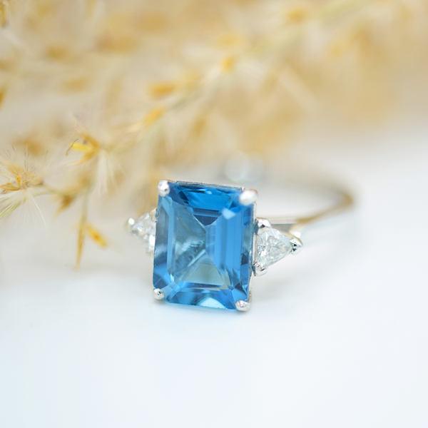 platinum emerald cut topaz and trillion diamond three stone ring